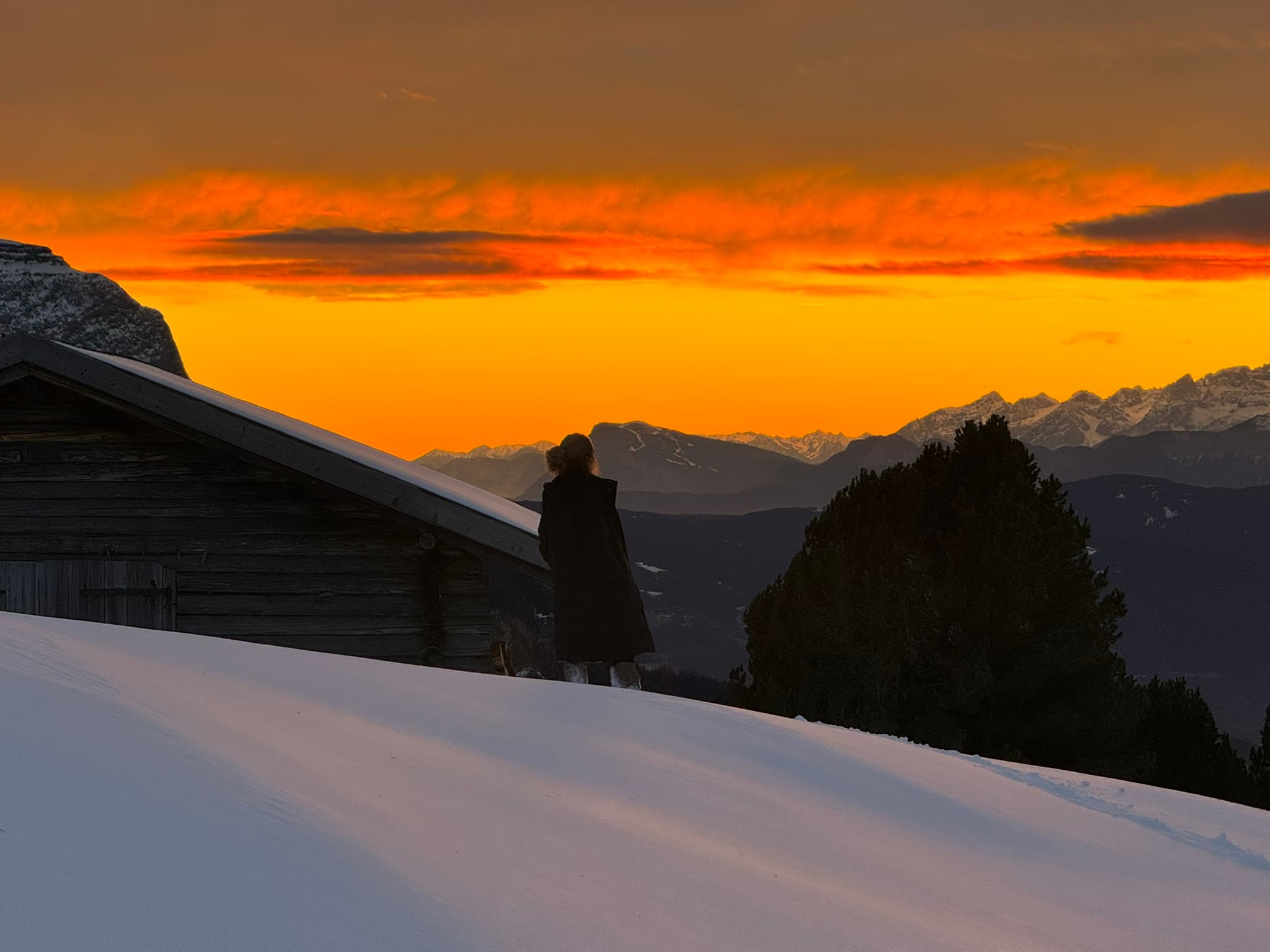 woman looking at golden sky, mountains